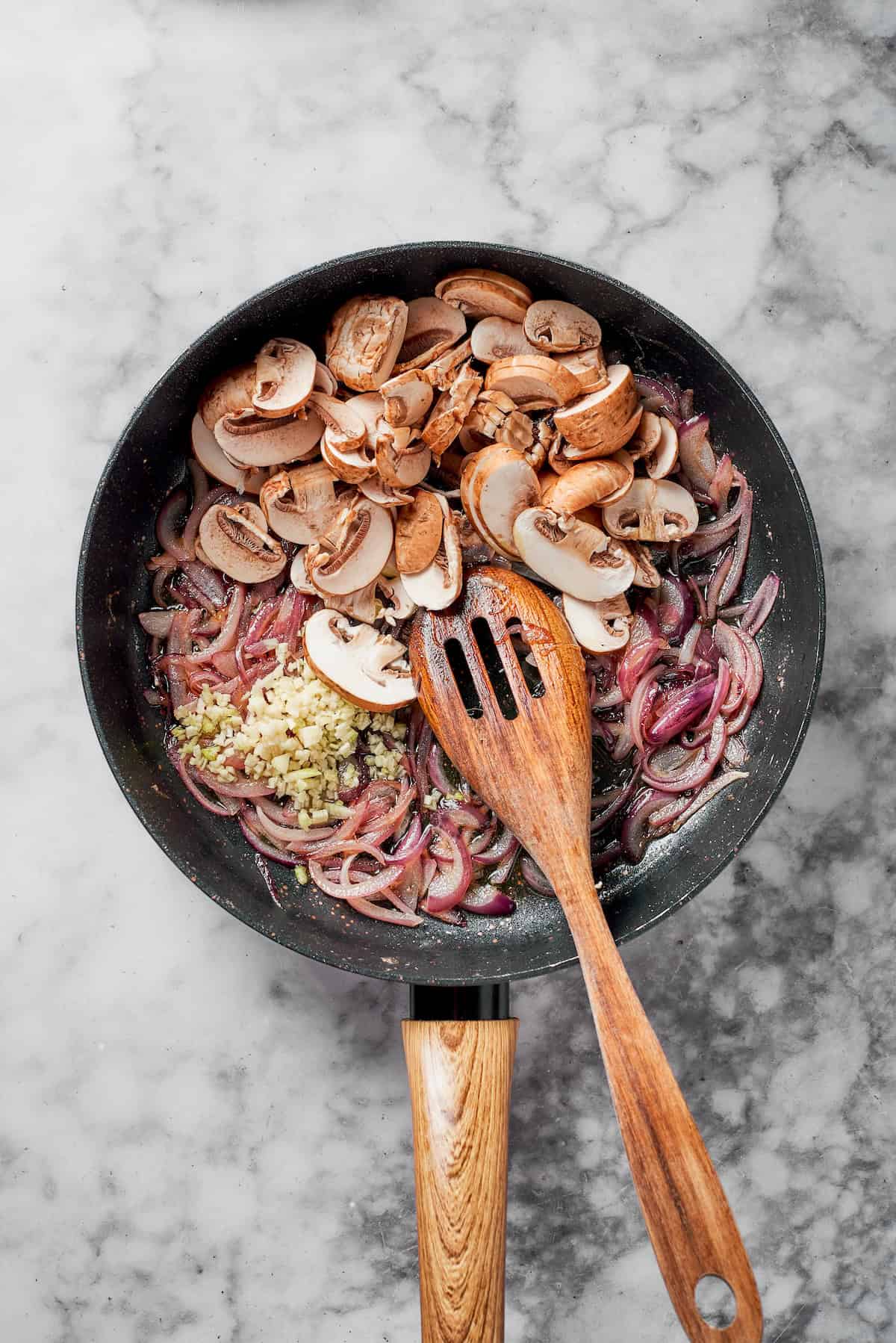 Mushrooms, onions and butter in a pan.