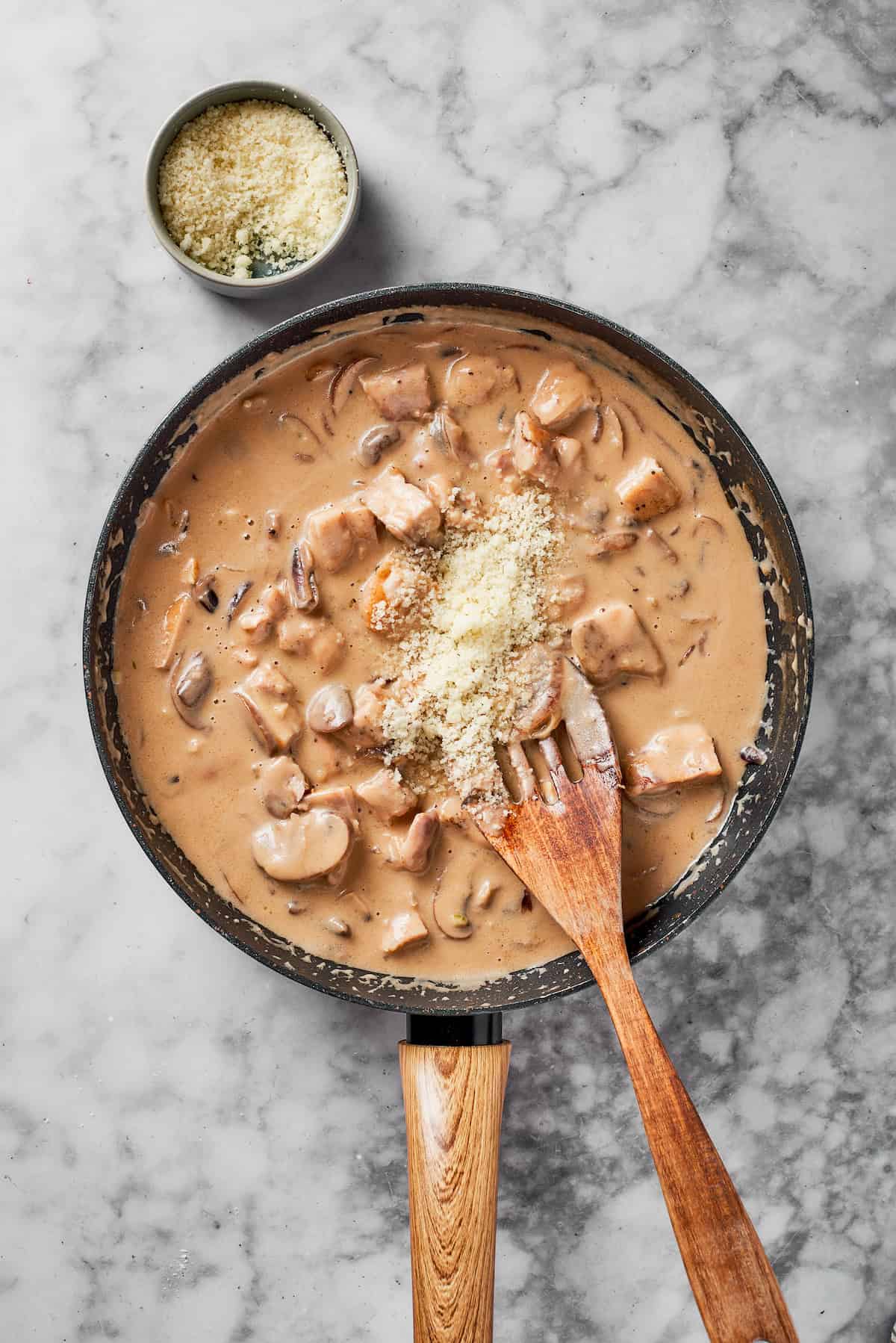 Adding chicken and cheese to the skillet.