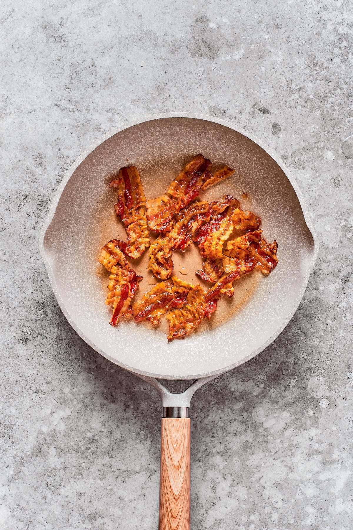 Bacon is cooked in a pan.