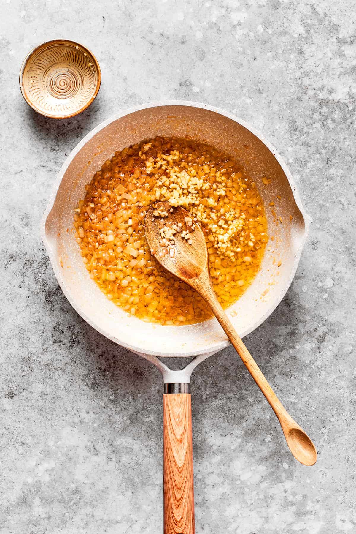 Garlic and shallot added to a pan.