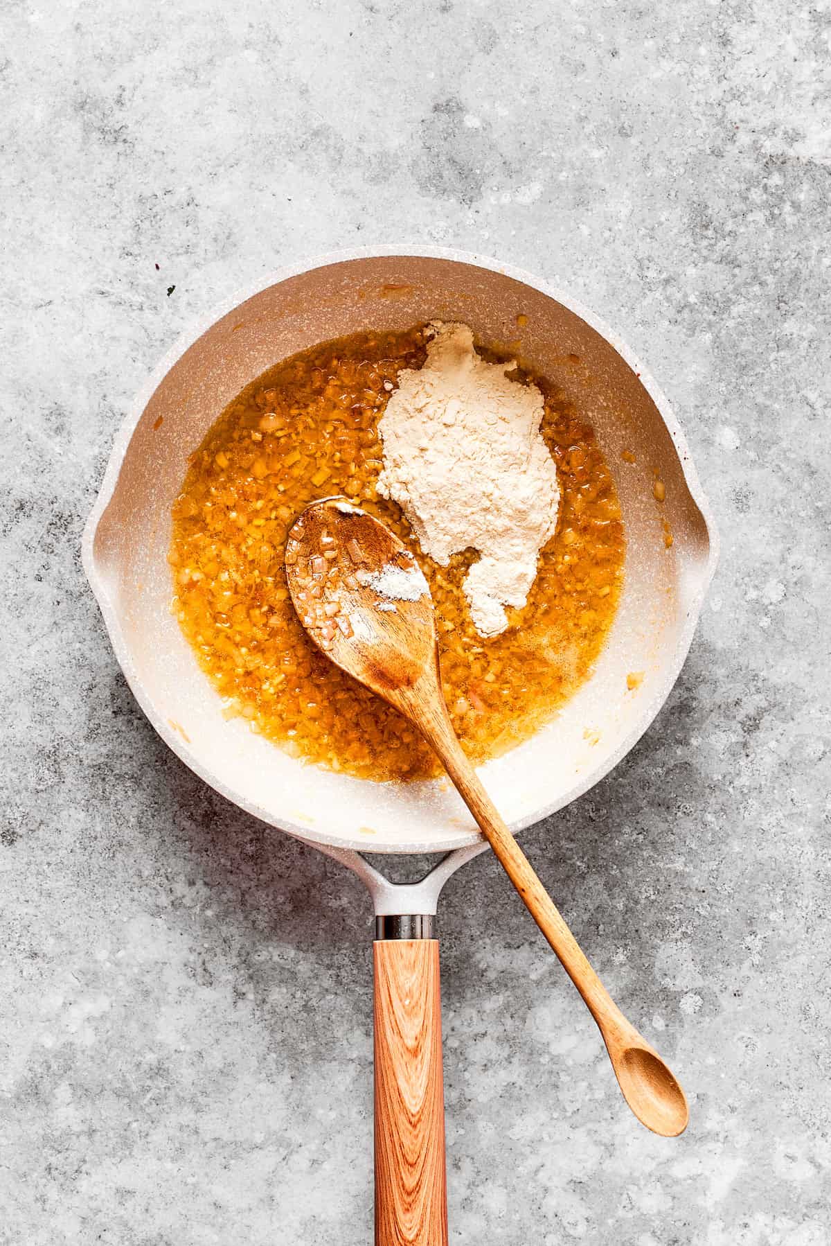 FLour is added to a pan.