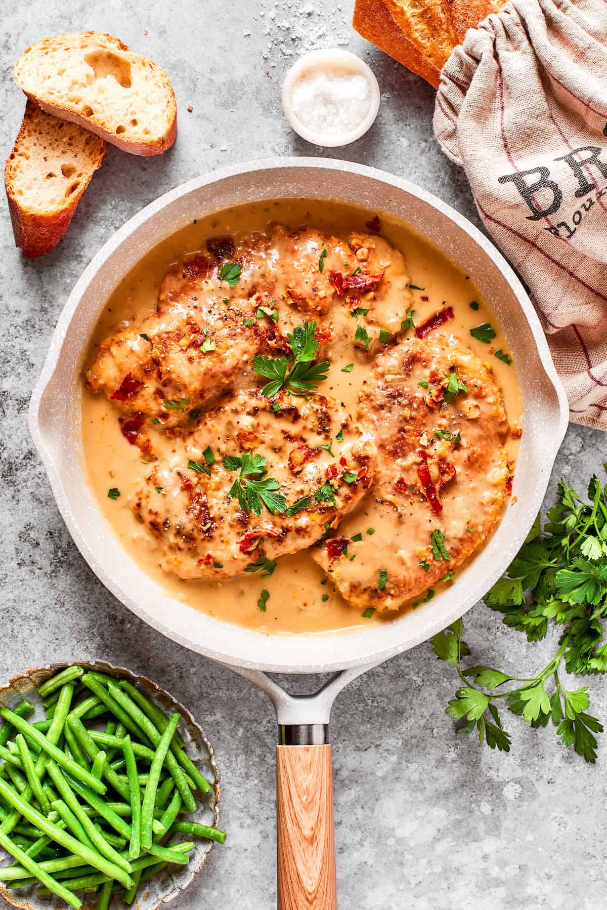 A pan of gravy and smothered chicken.