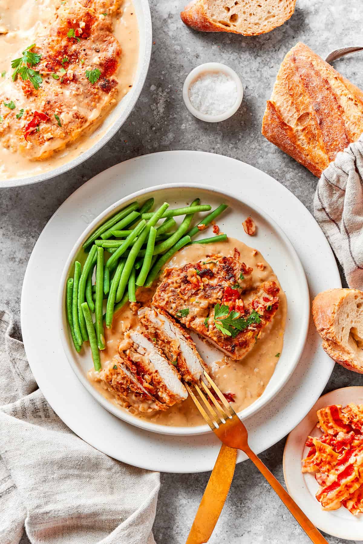 A plate of smothered chicken with green beans on a table.