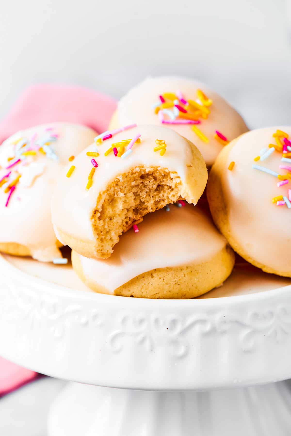 Anginetti cookies arranged on a white cake stand.