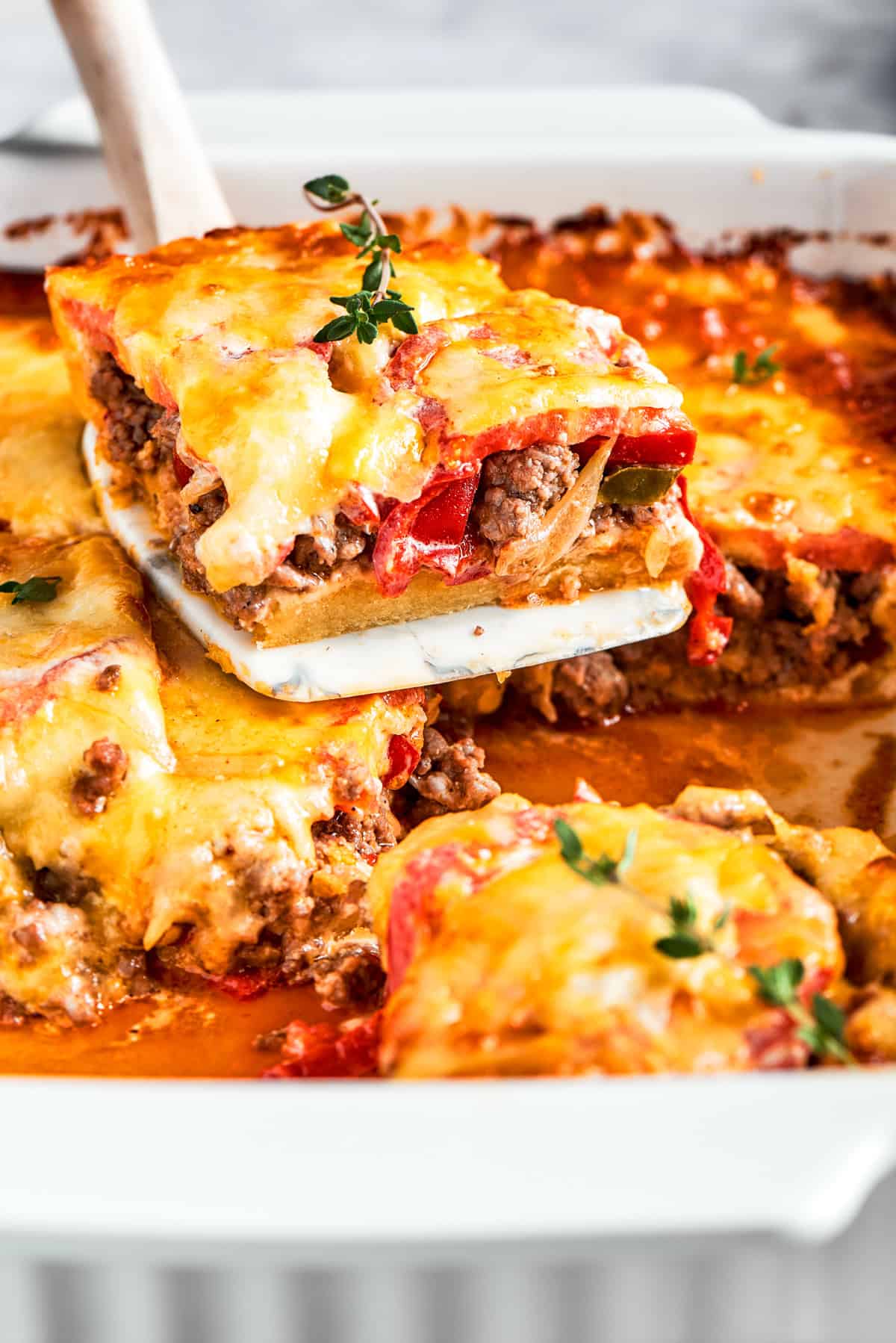 A slice of John Wayne Casserole being lifted out of the baking dish.