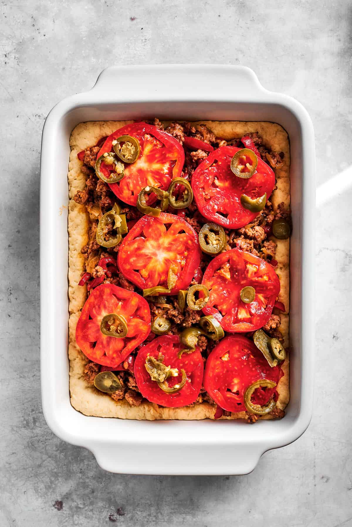 Tomato slices over meat and potatoes.