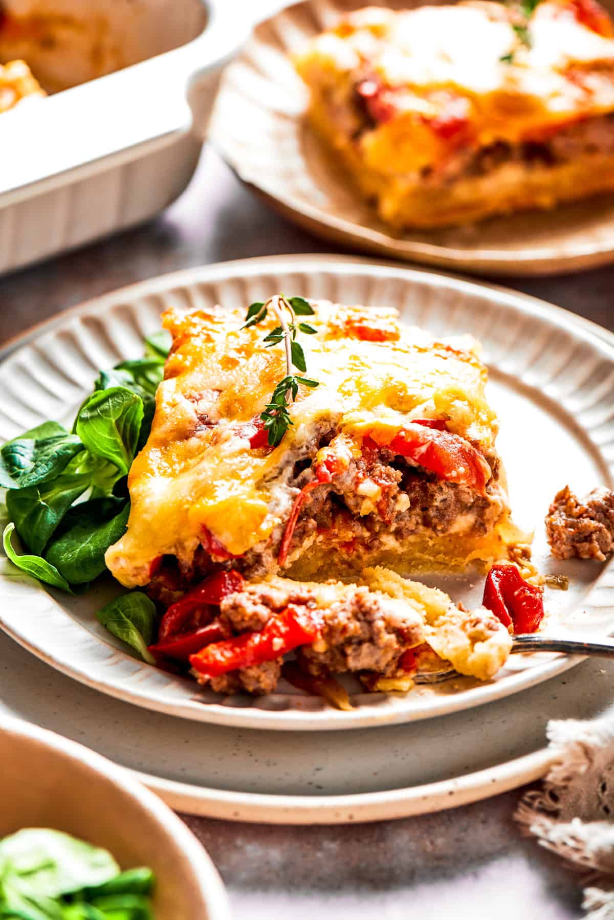 A slice of casserole resting on a dinner plate.