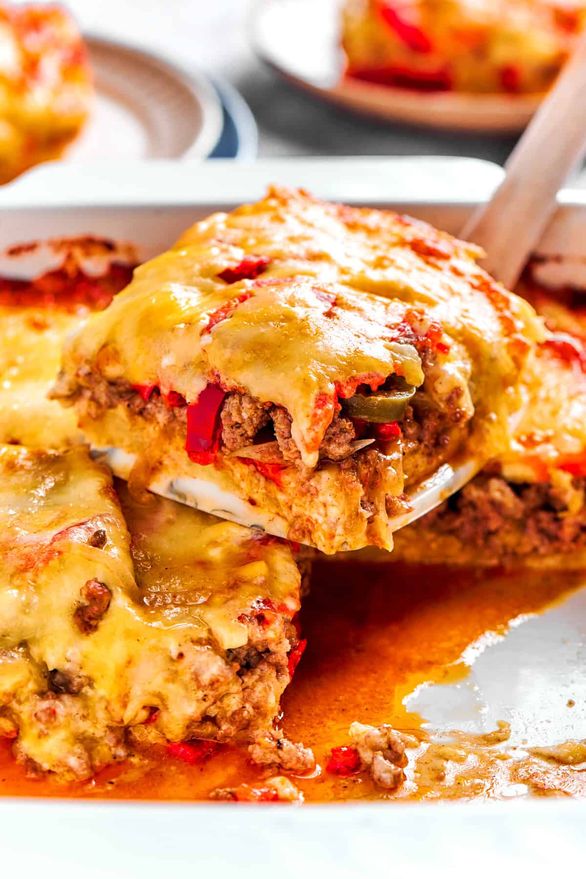 A slice of John Wayne Casserole getting scooped out of a casserole dish.