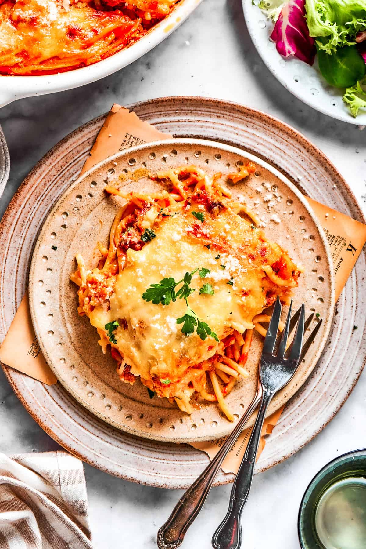 A serving of million dollar spaghetti served on a plate with forks.