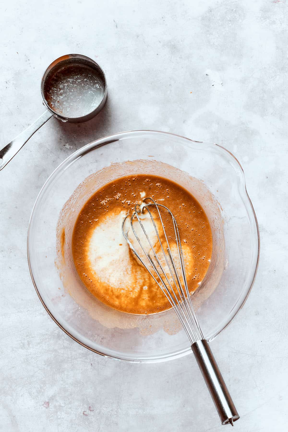 Buttermilk is whisked into a bowl of batter.