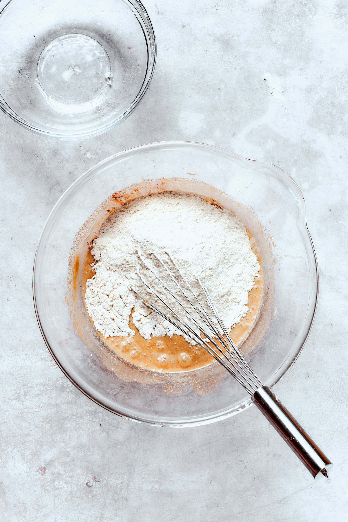 Whisking in dry ingredients to donut batter.