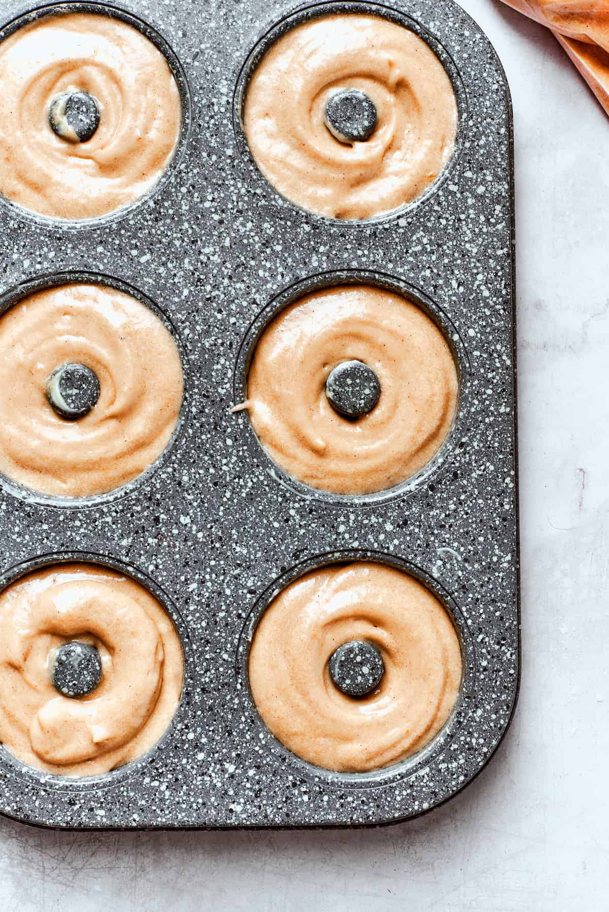 Apple cider donut batter in a donut pan.