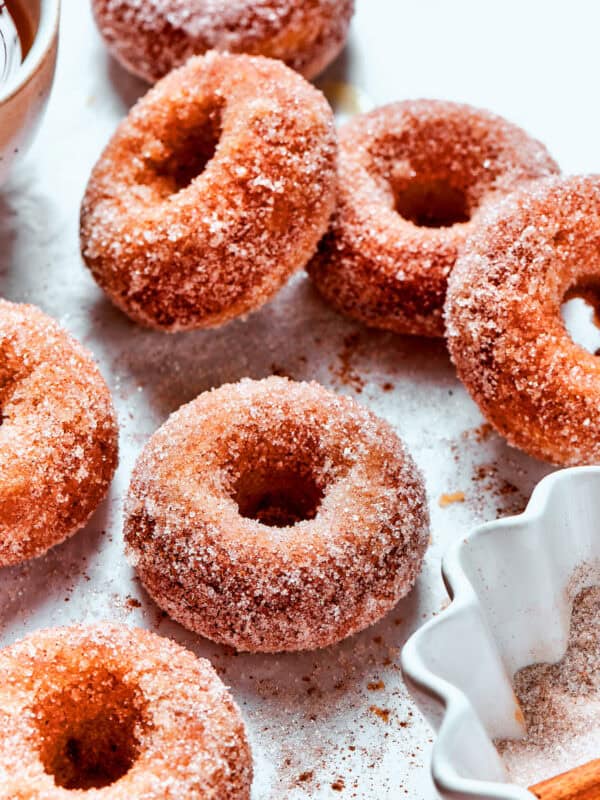 Cinnamon sugar sparkles on baked apple cider donuts.