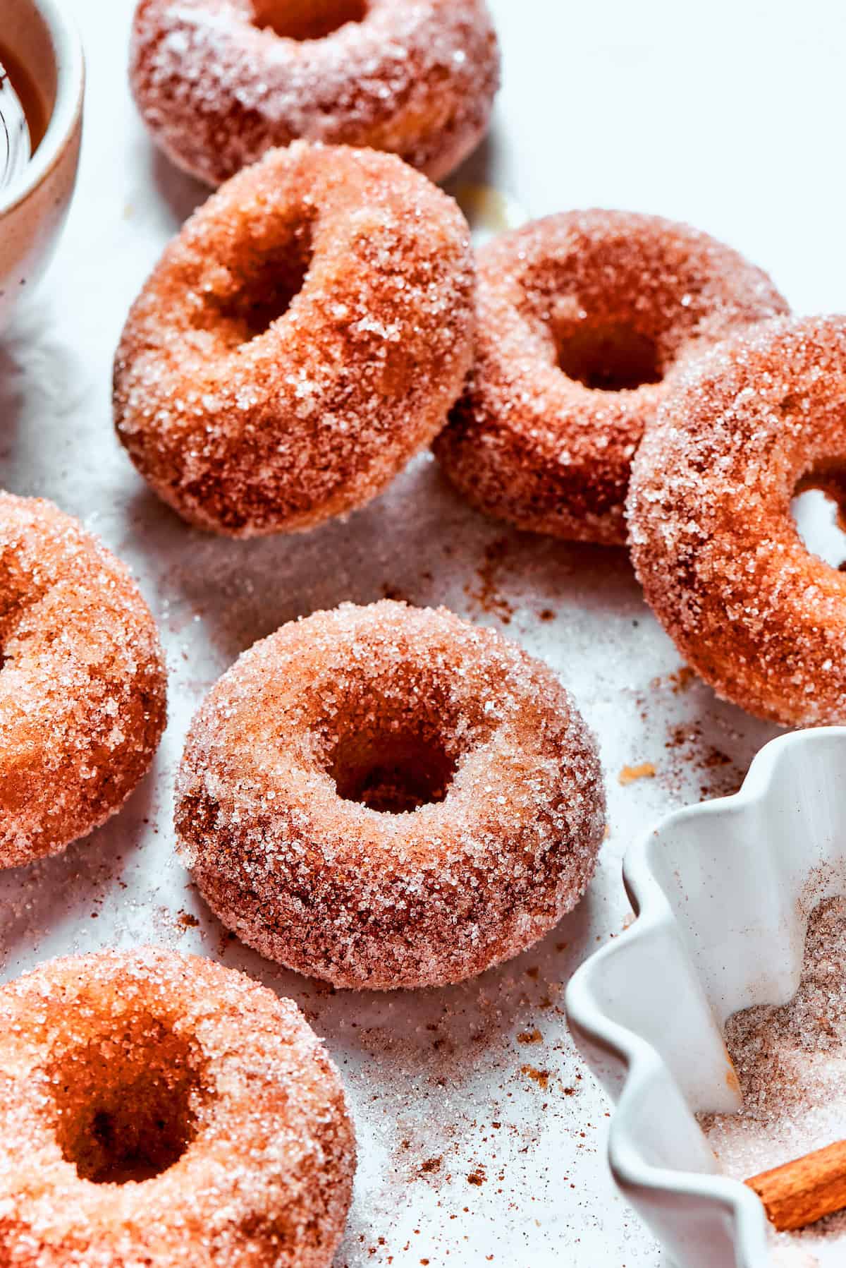 Cinnamon sugar sparkles on baked apple cider donuts.