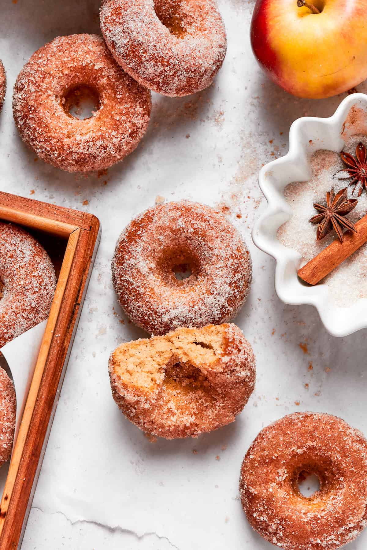 Apple cider donuts, one with a bite taken out.