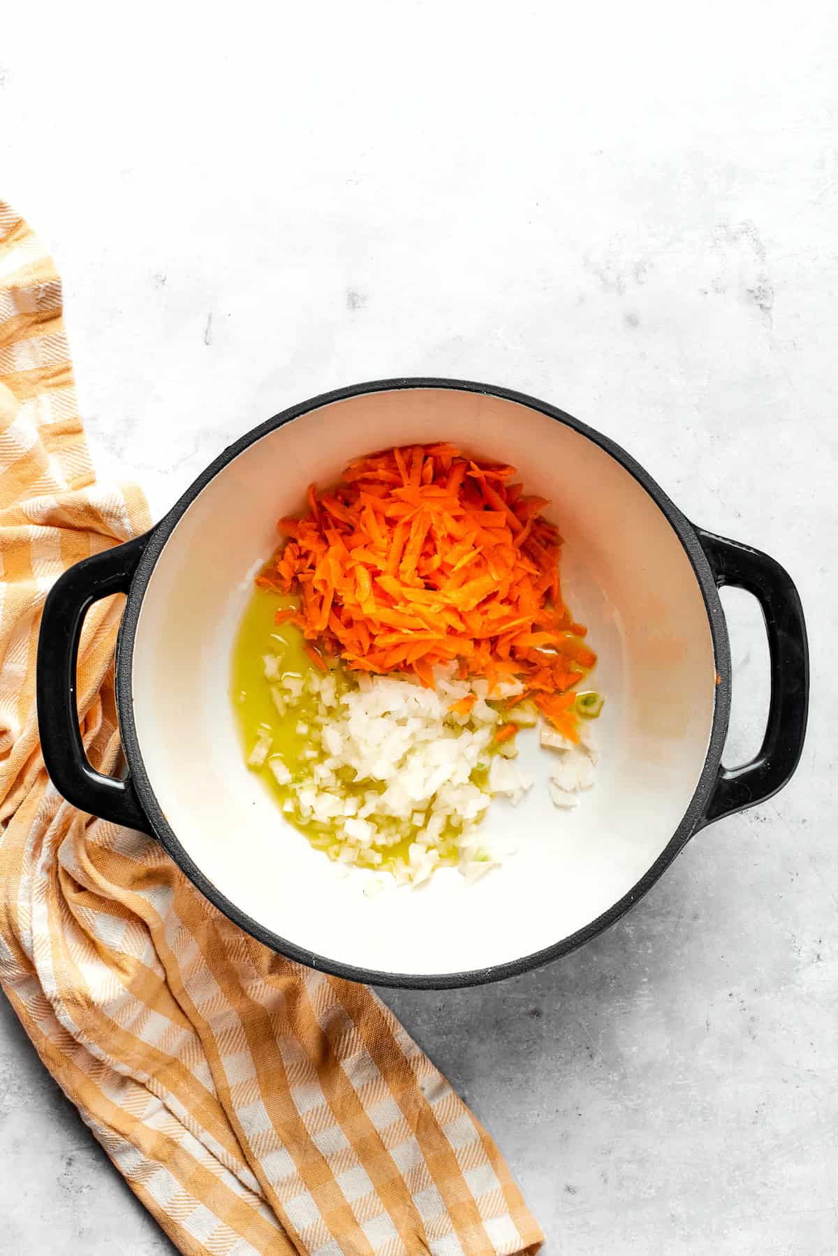 Cooking carrots and onion in a pot.