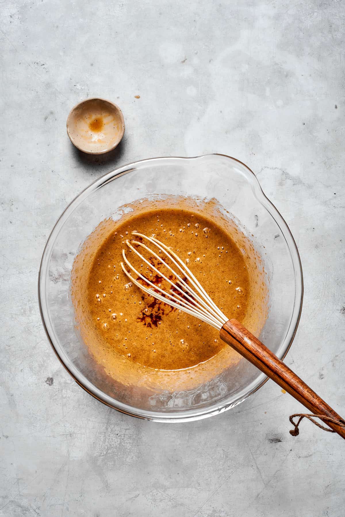 Eggs are whisked into browned butter in a bowl.