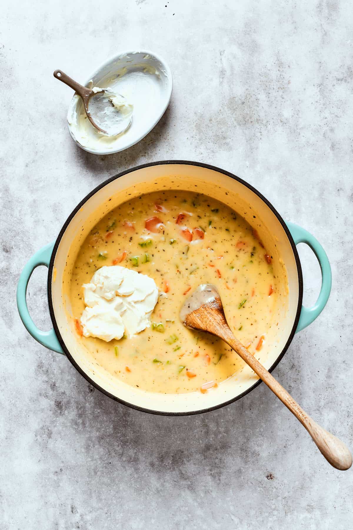 Adding cream cheese to the pot.