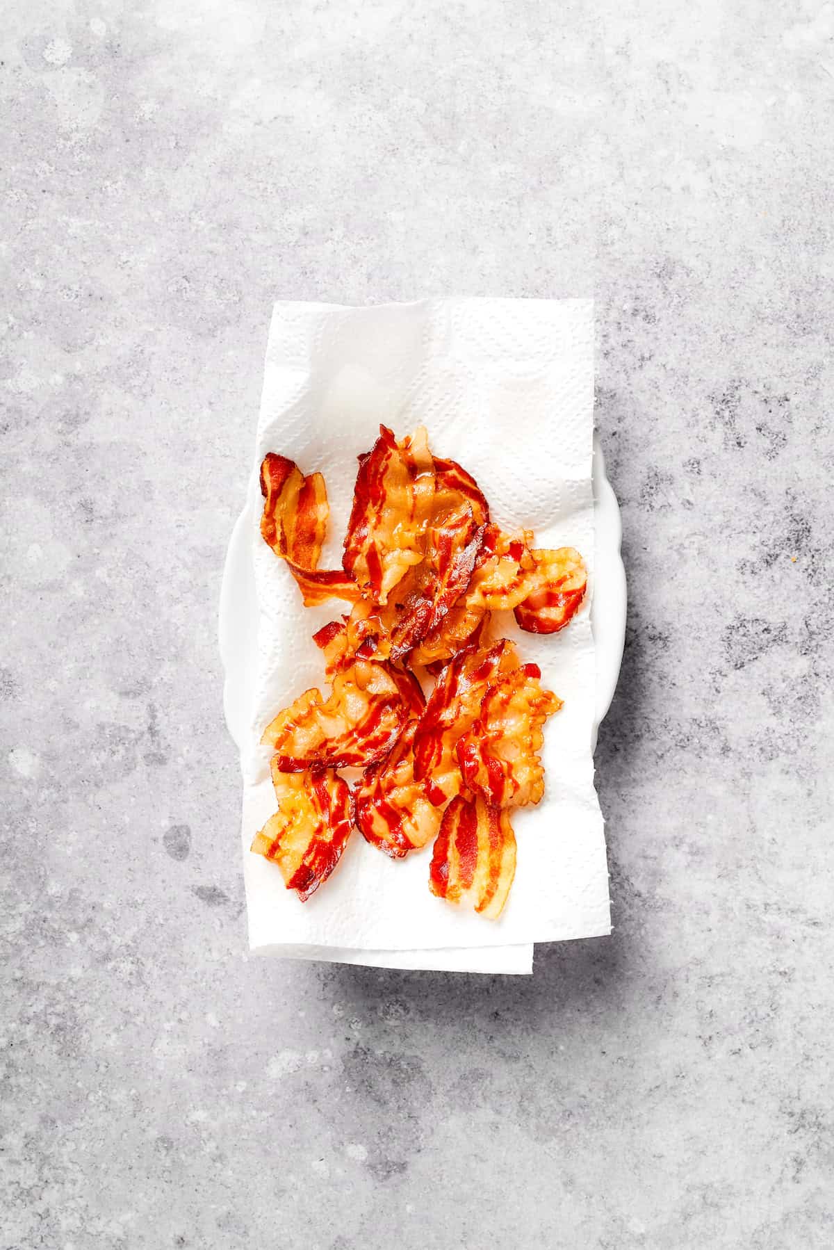 Cooked bacon drains on paper towels.