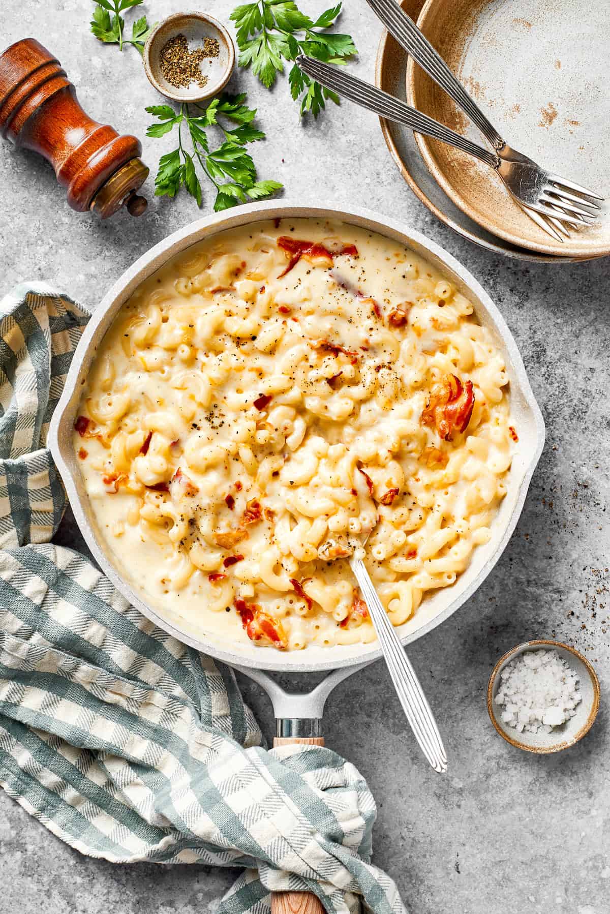 A pan of bacon mac and cheese and a spoon.