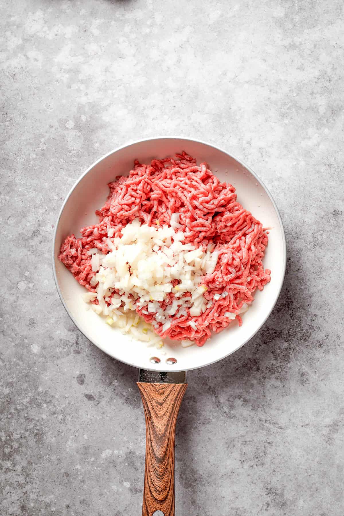 Ground beef and onion in a skillet.