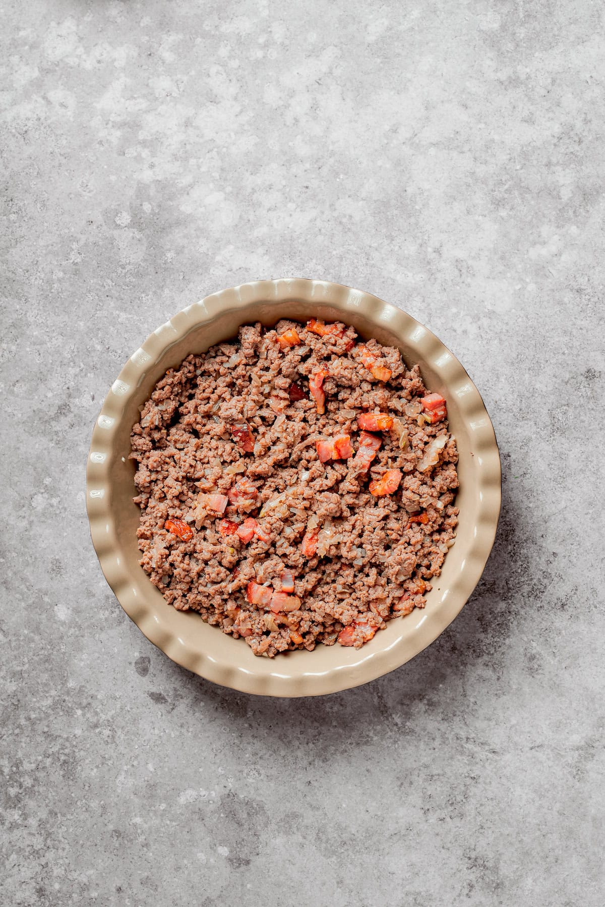 Cheeseburger pie filling in a pie pan.