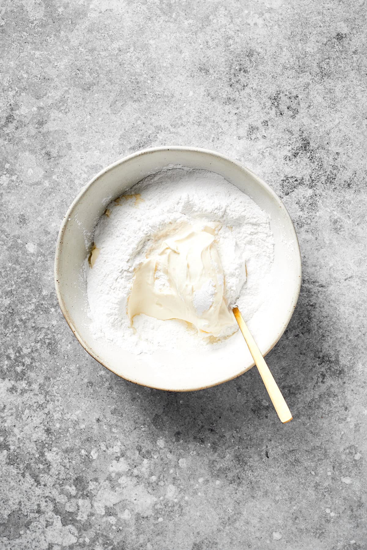 Cream cheese and powdered sugar mixed together in a bowl.