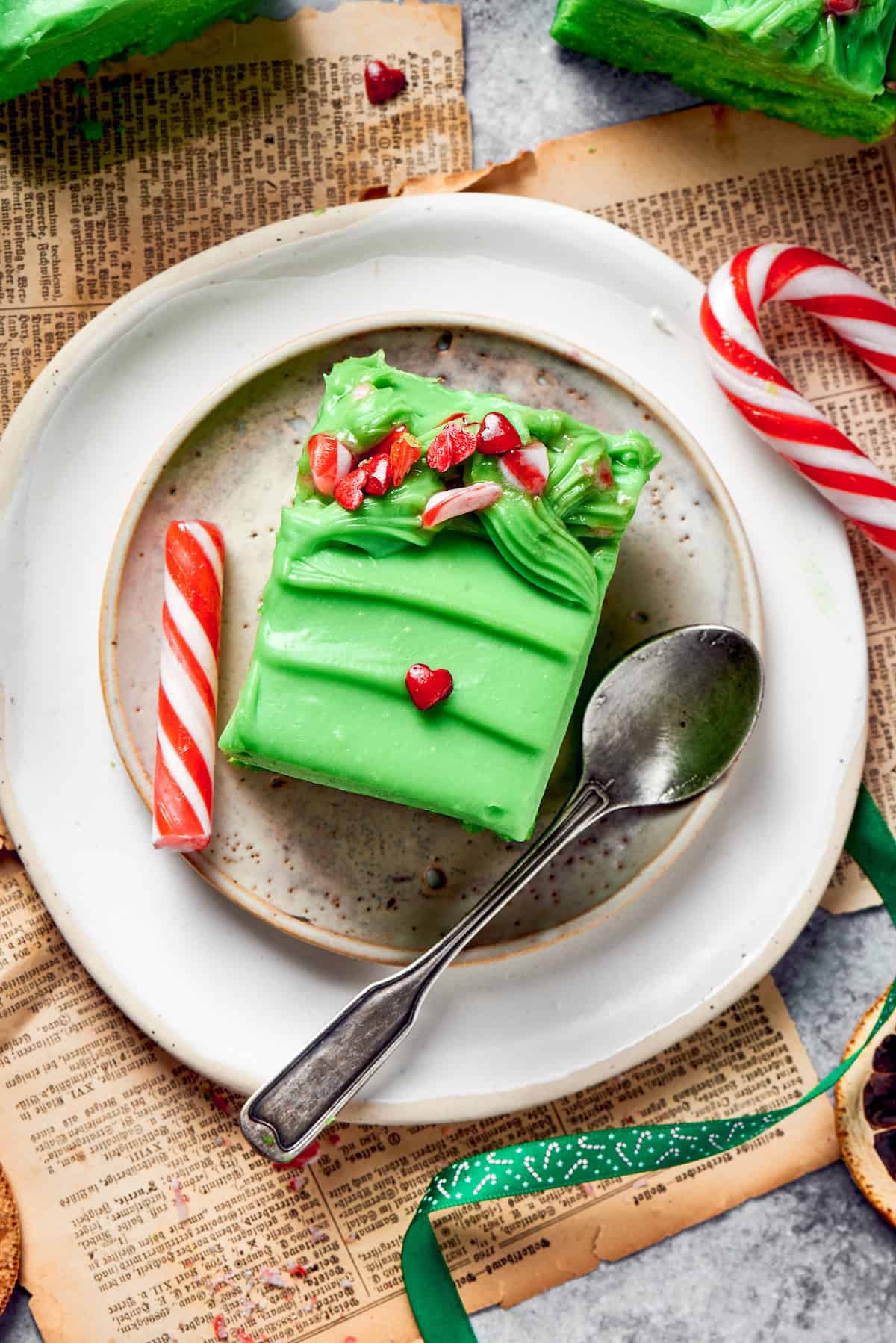 A plate with a slice of grinch cake and a spoon.