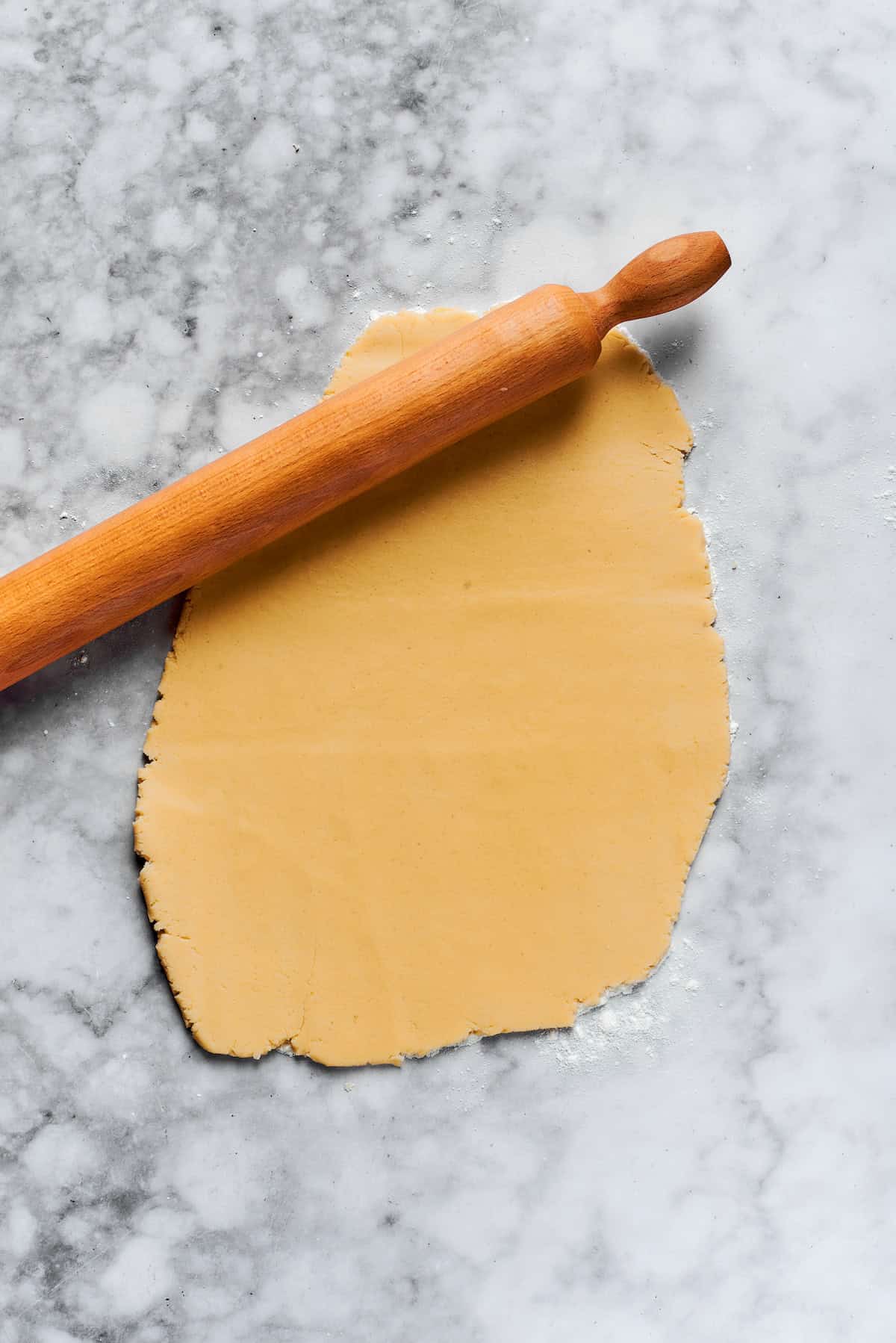 A rolling pin rolls out cookie dough.