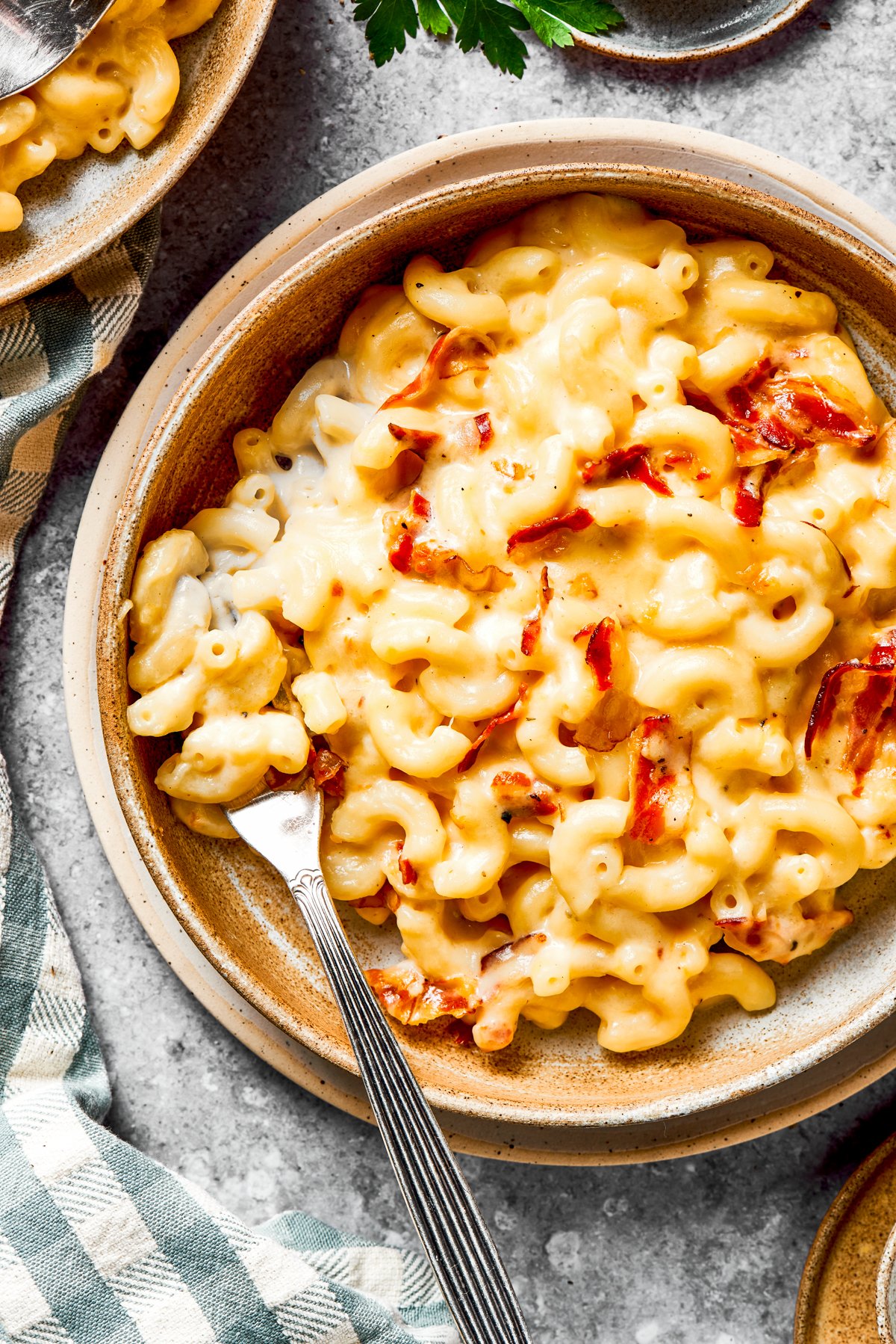 Mac and cheese served in a bowl with a fork resting inside the bowl.