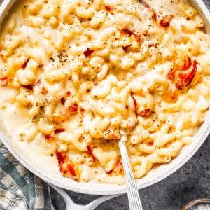 A skillet with mac and cheese and bacon stirred in.