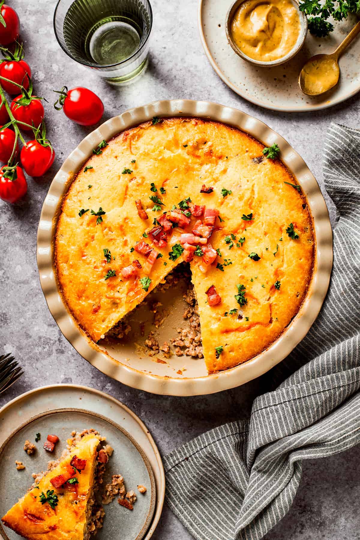 Overhead image of cheeseburger pie in a pie dish, with one wedge cut out.