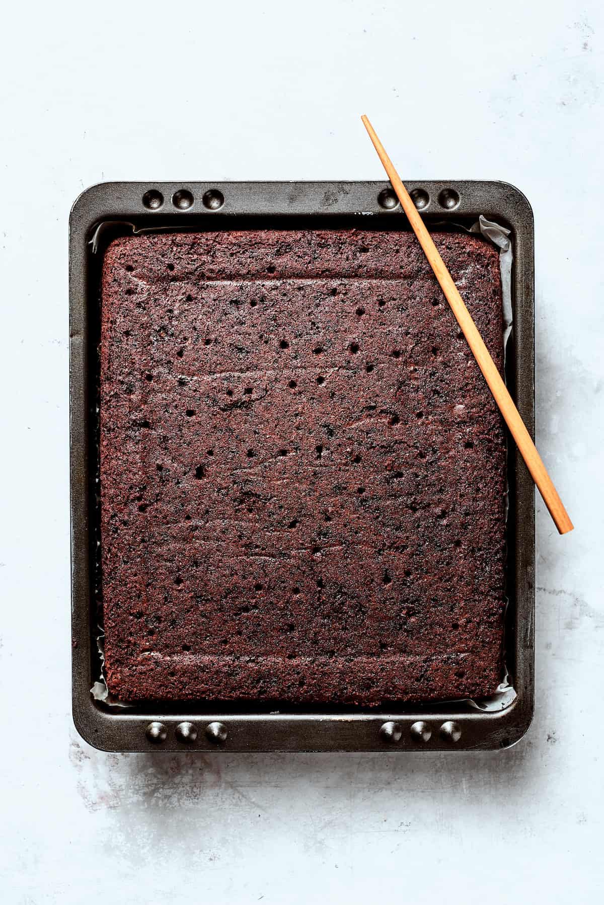 Chocolate cake cools in a tin.