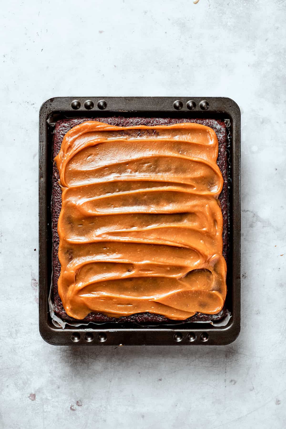 Caramel spread over the top of a chocolate cake.