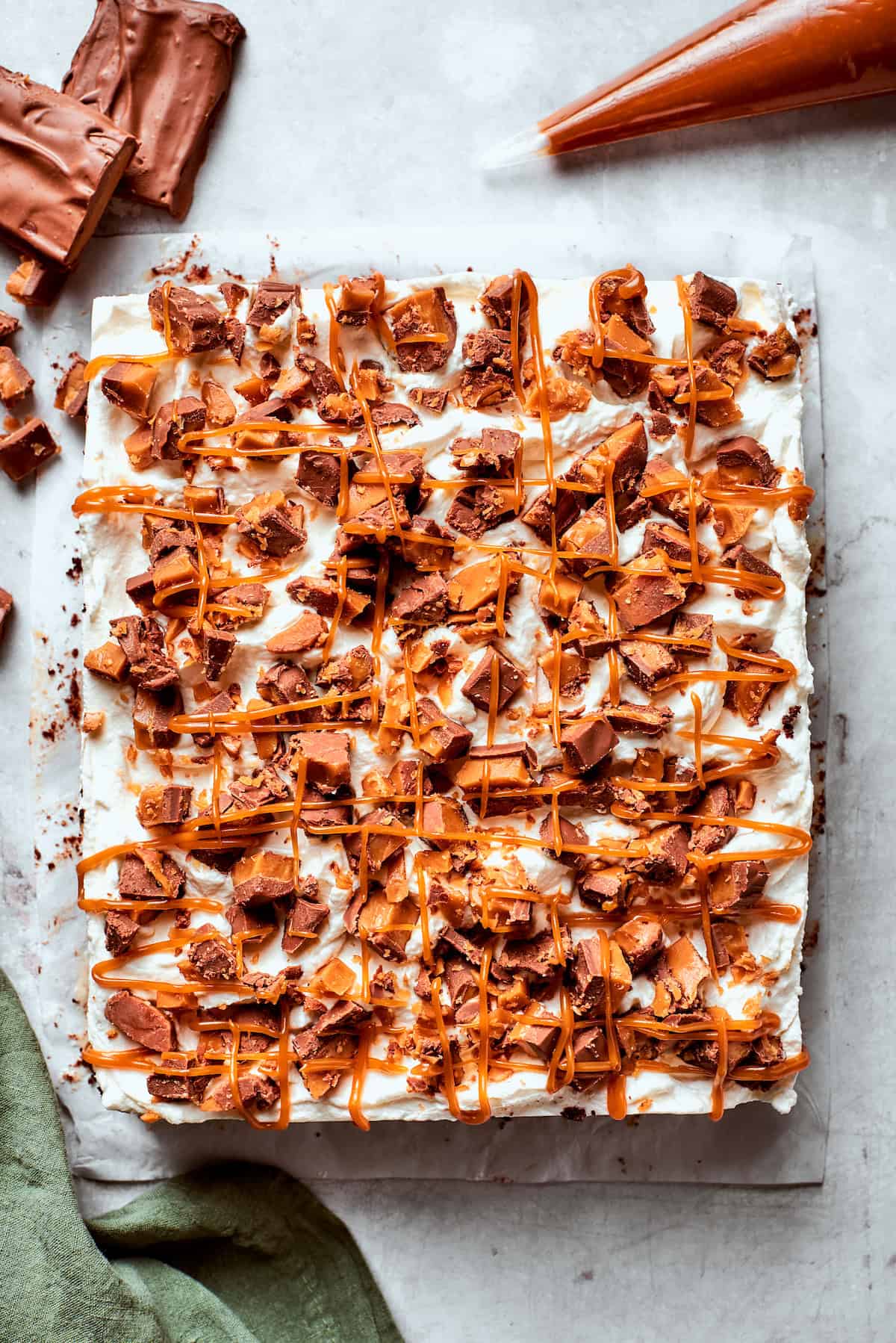 A better than sex cake topped with chopped candy bars.