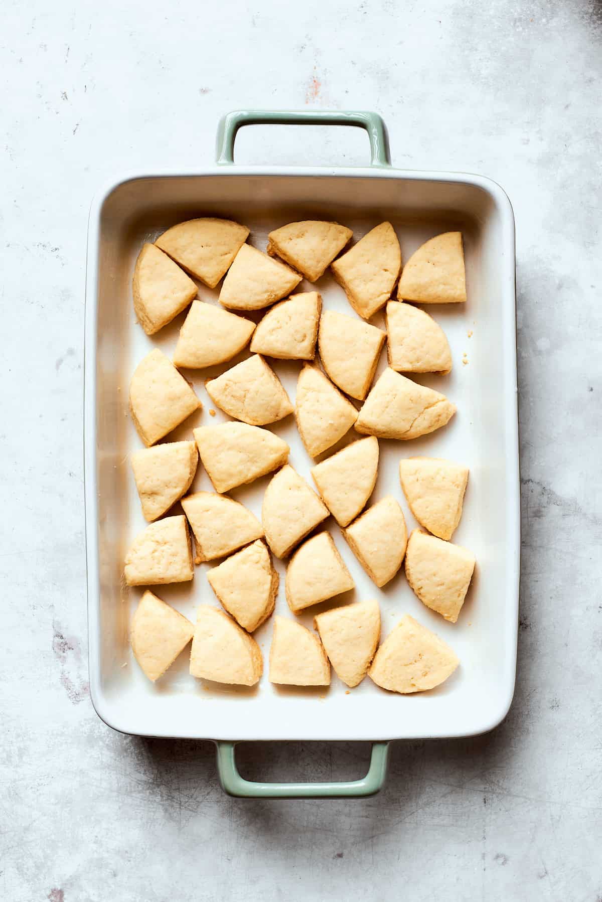 Pieces of biscuit dough in a baking pan.