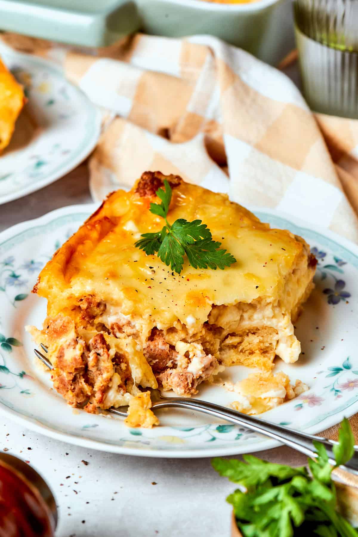 A fork cuts into a piece of biscuits and gravy casserole.