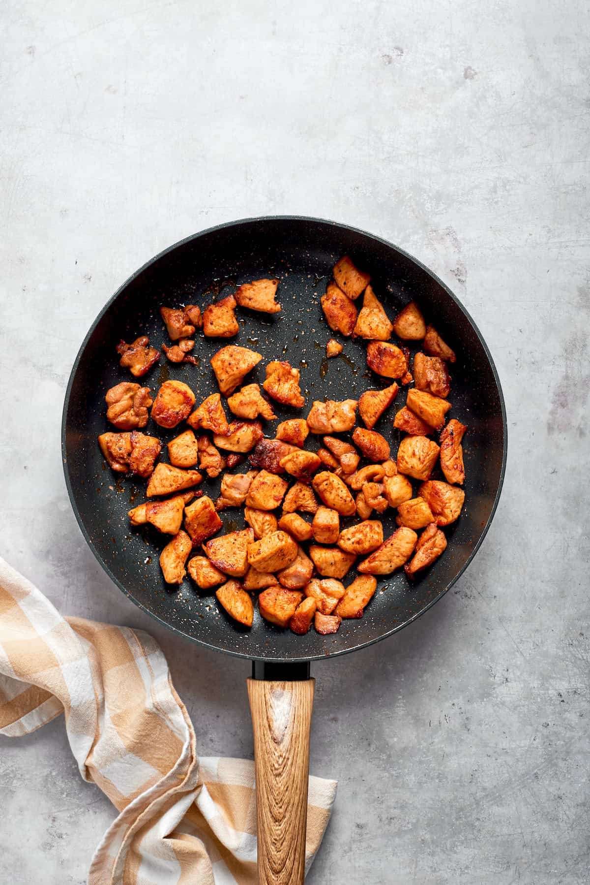 Chicken pieces cooked until brown in a skillet.