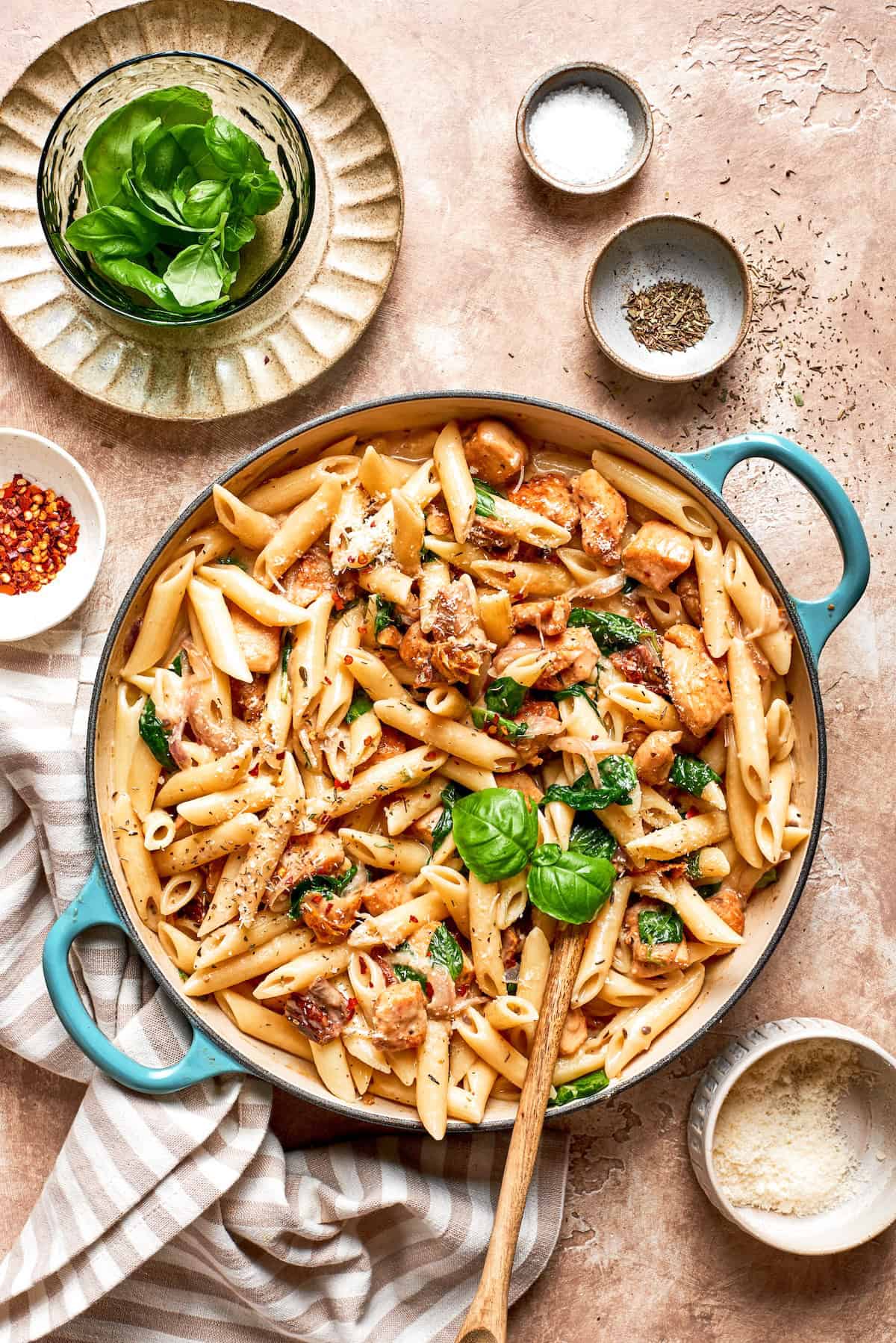 A skillet of marry me chicken pasta on a table.