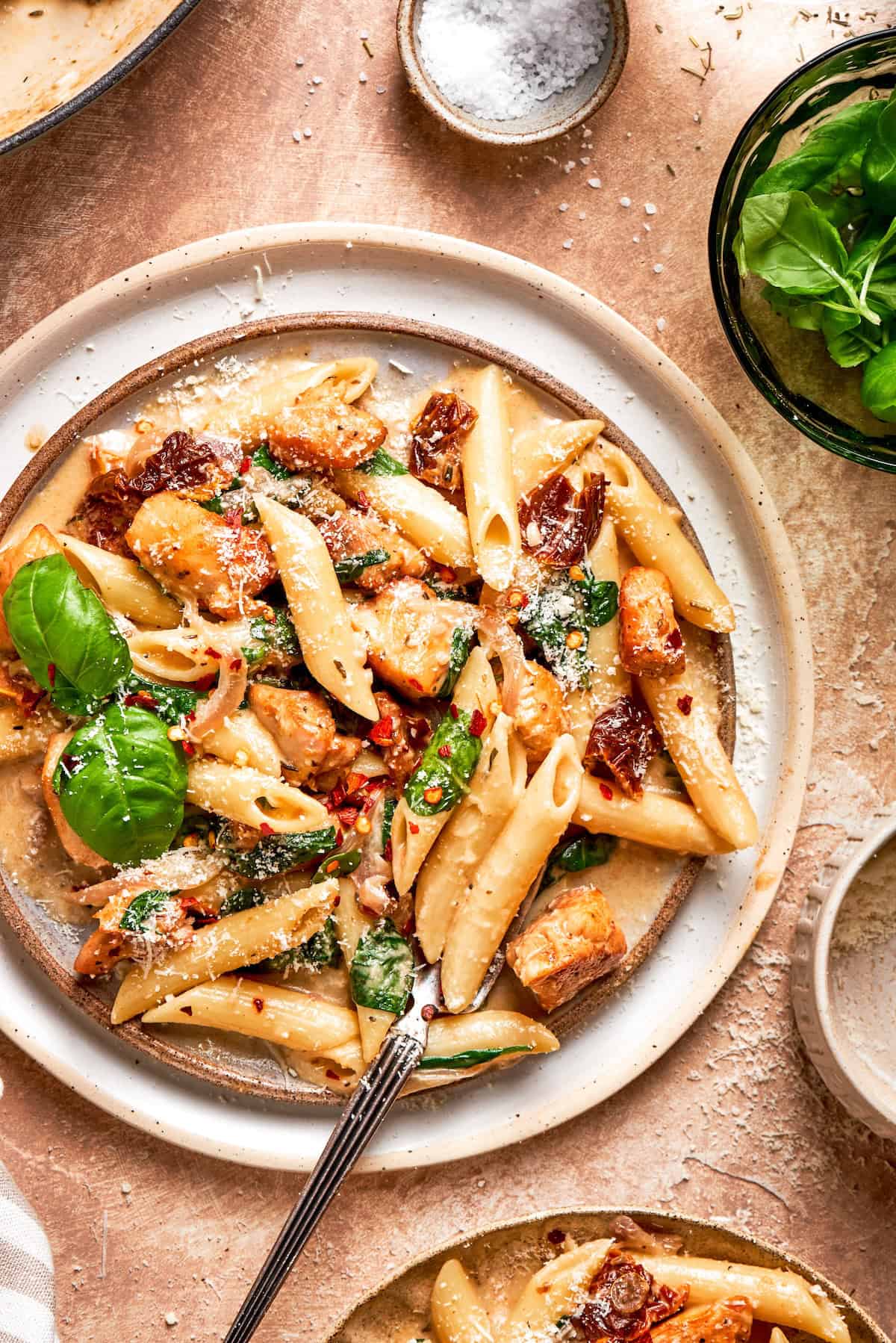 Basil leaves garnish a big plate of marry me chicken pasta.