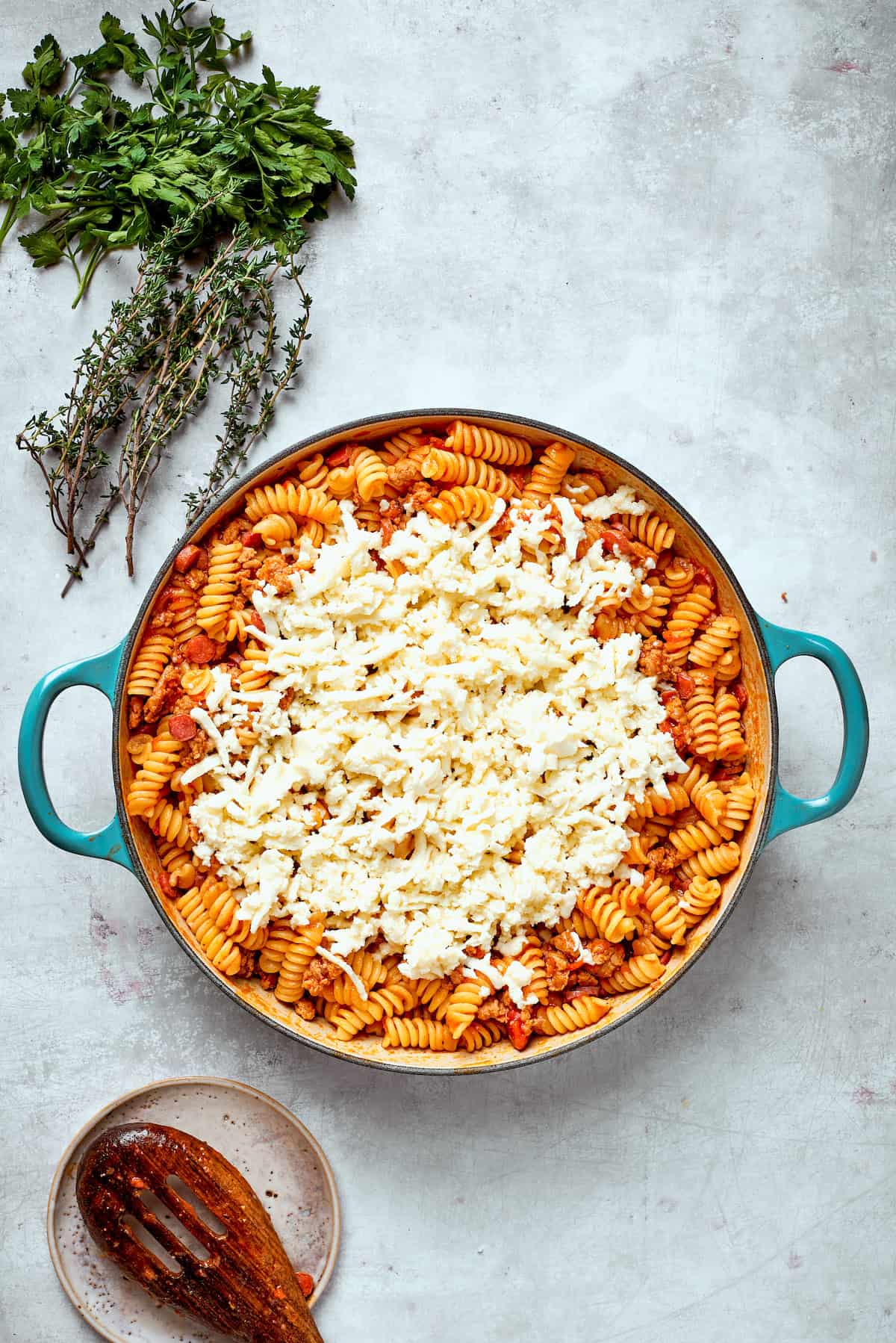 Cheese is added to a pan of pizza pasta.