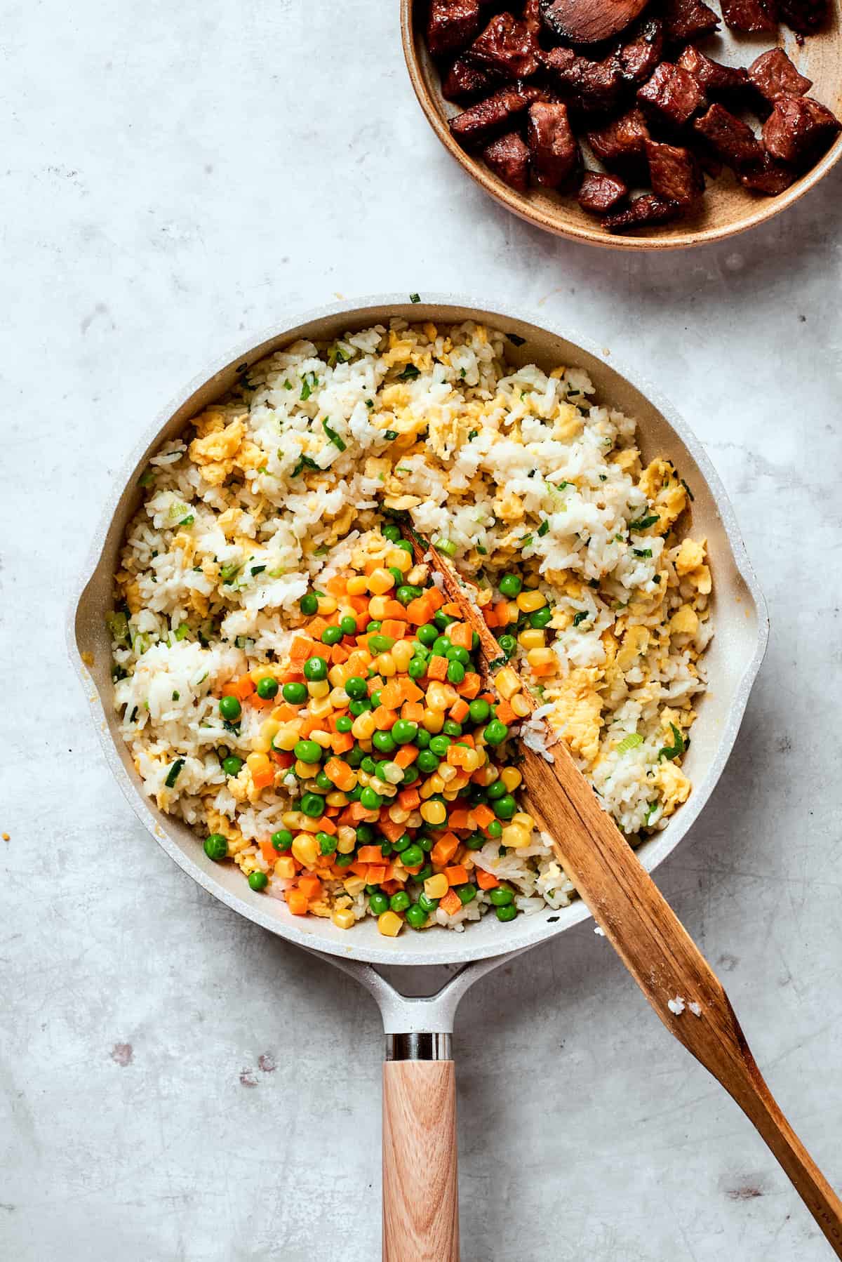 Veggies are added to fried rice.