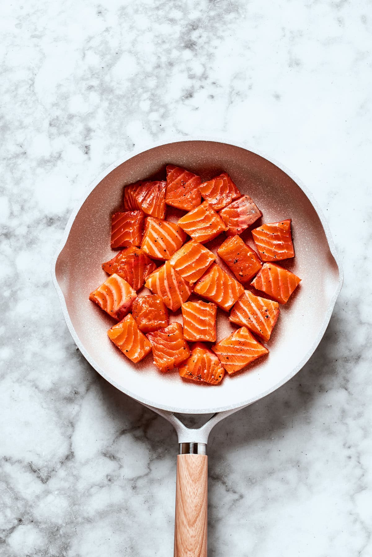 Salmon cubes in a skillet.