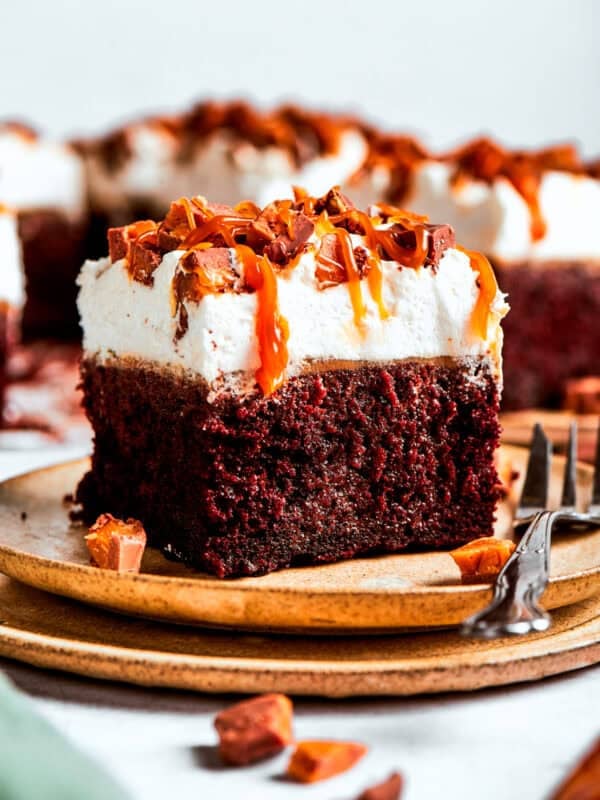 A slice of chocolate cake served on a plate with a fork placed next to it.