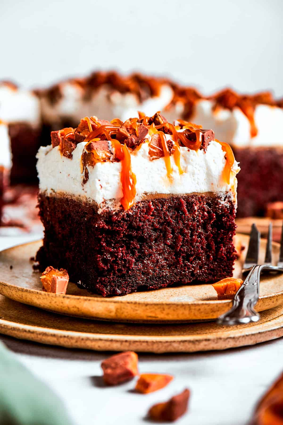 A slice of chocolate cake served on a plate with a fork placed next to it.