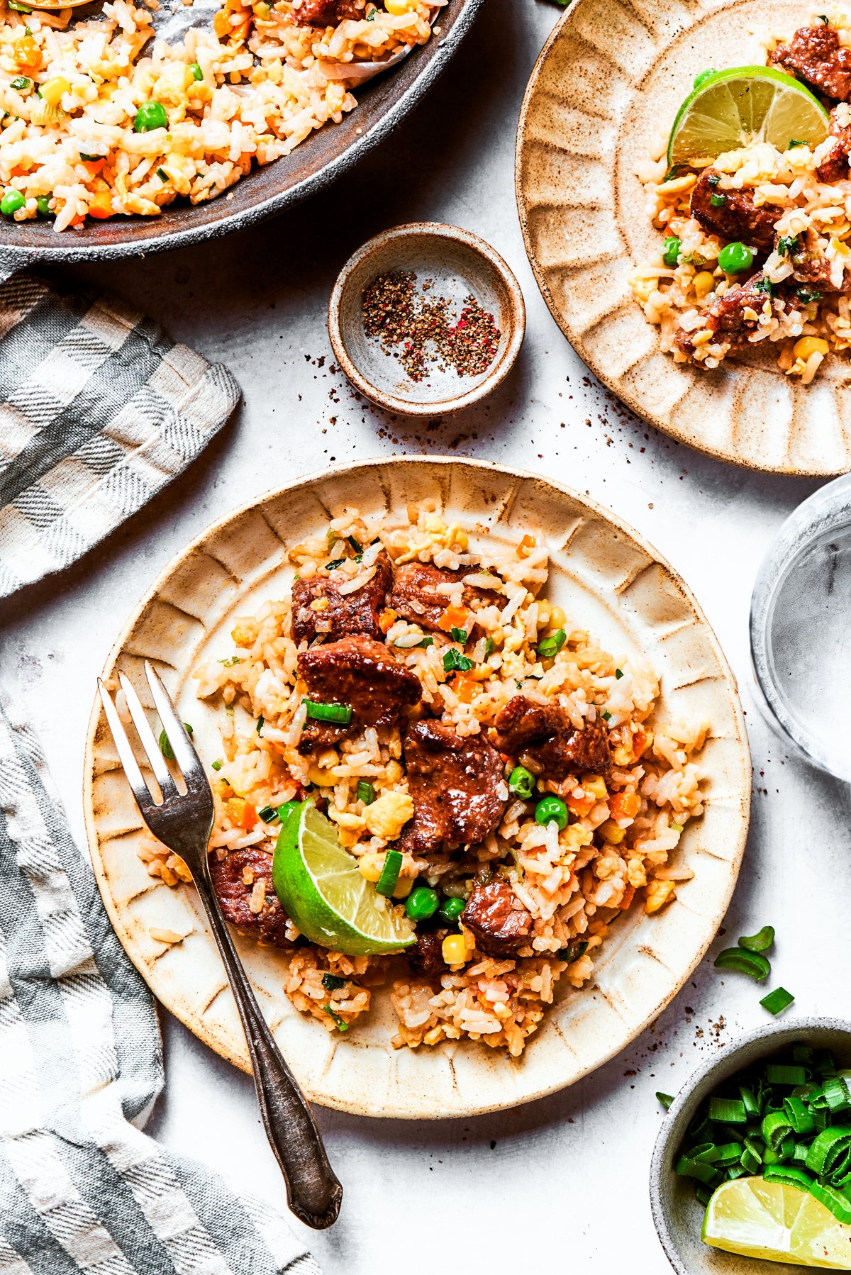 Steak fried rice served on a dinner plate with a fork.