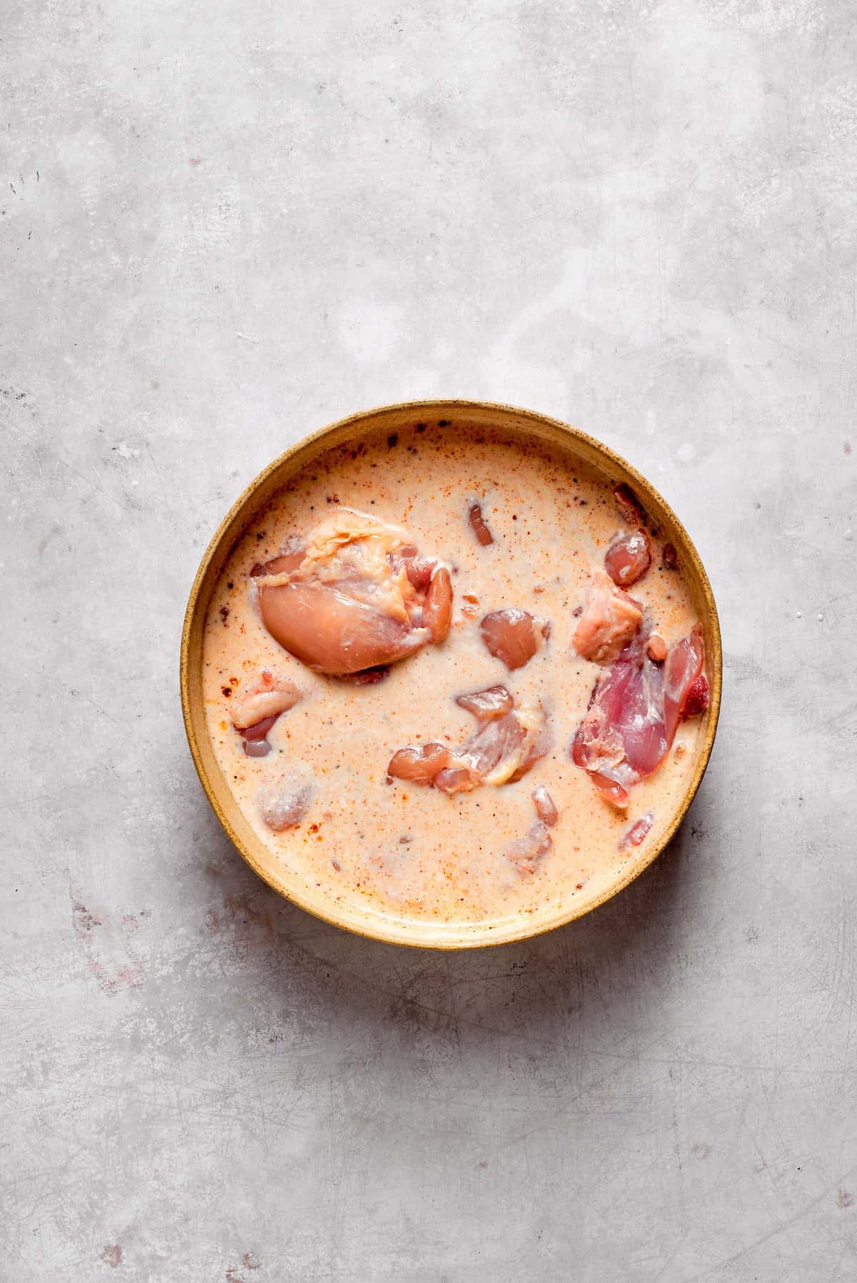 Chicken thighs marinate in buttermilk.