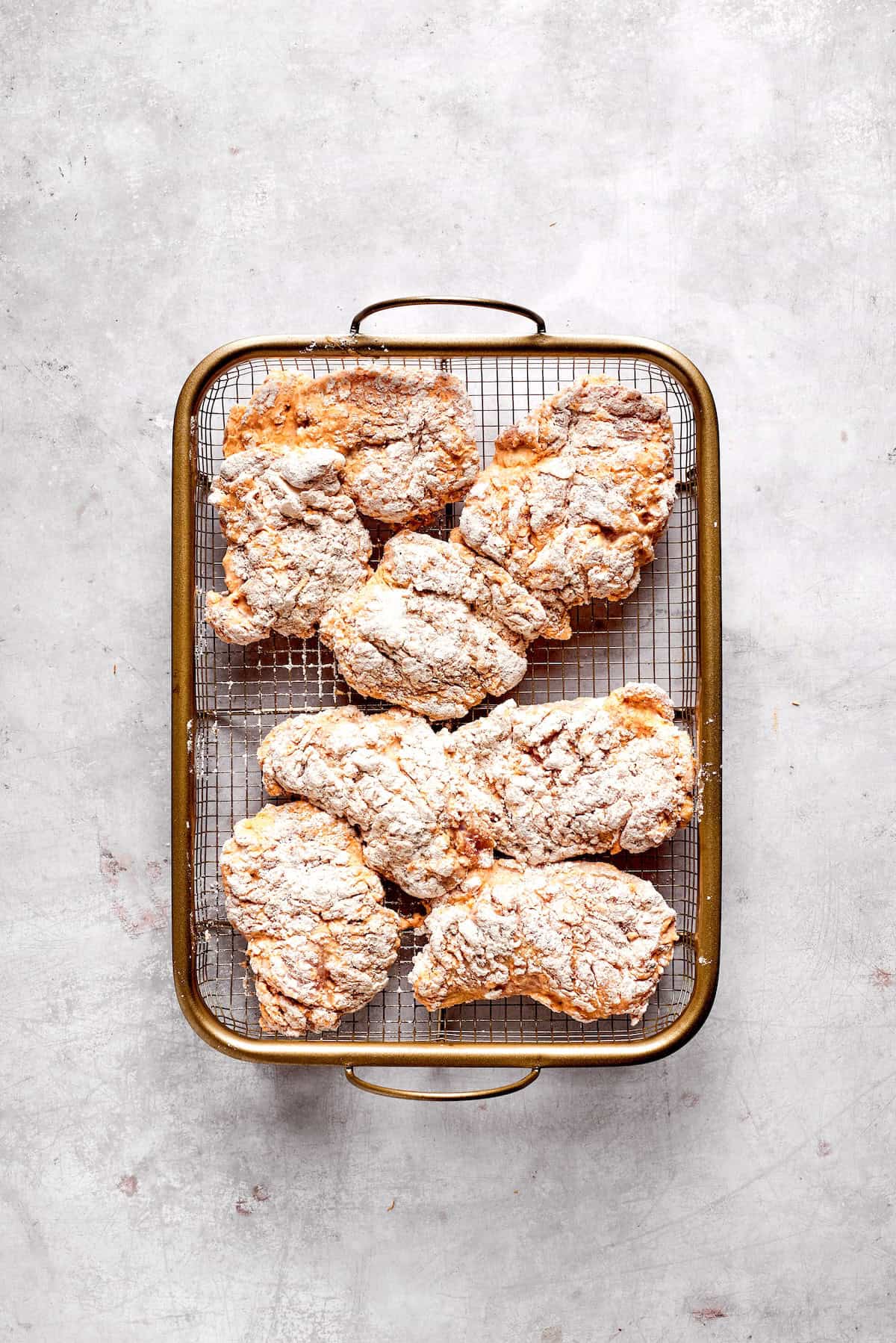 Coated pieces of chicken are ready to fry.