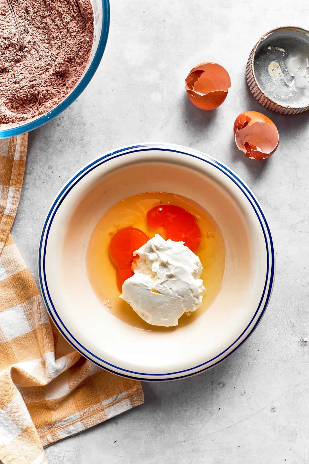 Eggs are mixed with sour cream in a bowl.