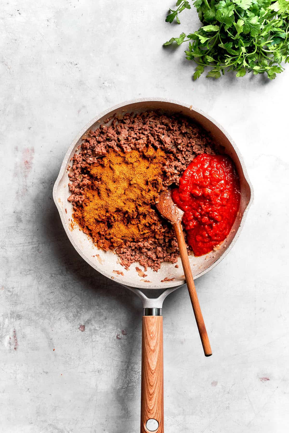 Beef browns in a skillet with taco seasoning.